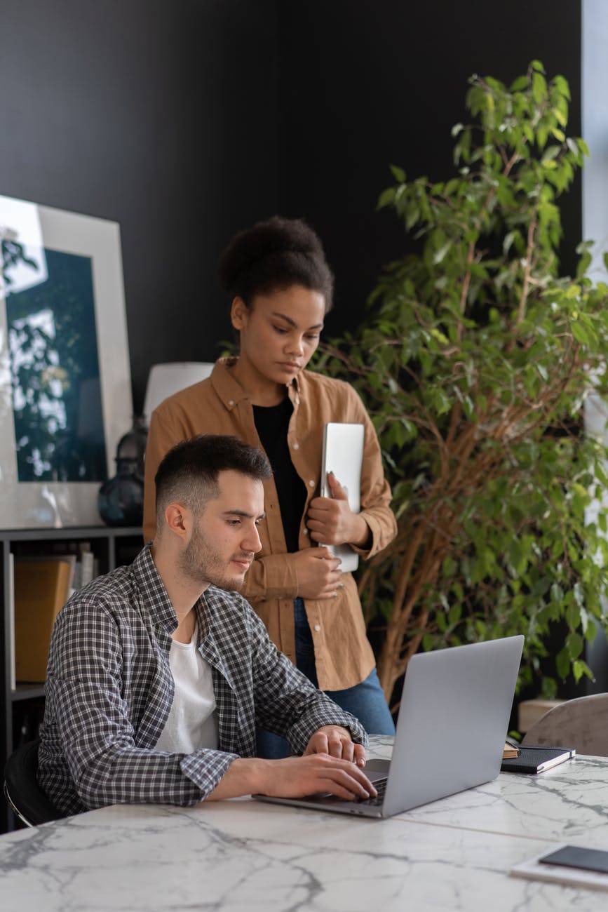 man and woman looking a laptop together